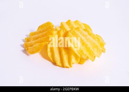 Corrugated chips isolated on white background, wavy potato chips, crispy snack close up. Stock Photo