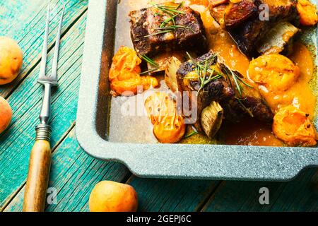 Beef ribs stewed in apricots. Braised meat with fruit sauce Stock Photo