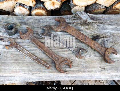 Antique wrenches on a wooden background, rusty tools, metal waste, scrap metal, wrench collection Stock Photo