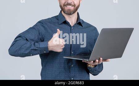 Unshaven man cropped view show thumbs up hand gesture holding portable laptop computer, approval Stock Photo