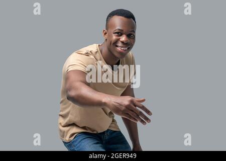 Studio picture of dark-skinned man in a beige tshirt Stock Photo