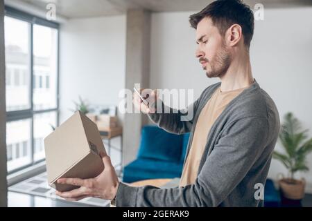 Male employee aiming her camera at the QR code Stock Photo