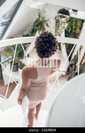 Back view of woman with laptop standing on stairs Stock Photo
