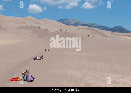 Colorado, San Luis Valley, Great Sand Dunes National Park. Large sand dunes ranging up to 750 feet tall. Tourists enjoying the dunes. Stock Photo