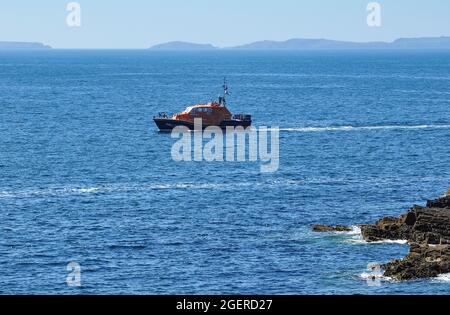 St David's Tamar class lifeboat 16-26 'Norah Wortley' off the coast at Porthclais with Skomer Island in the distance, Pembrokeshire, Wales, UK Stock Photo