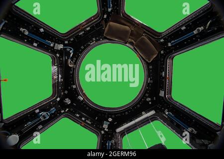 Porthole of space station isolated on green background. Elements of this image furnished by NASA. Stock Photo