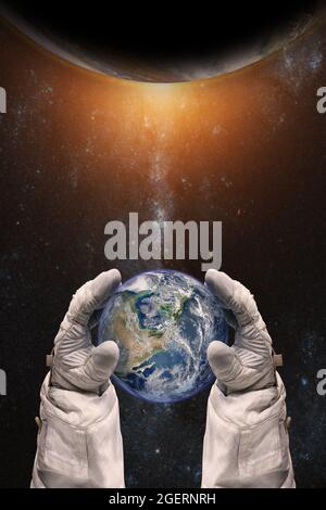 Earth in the hands of astronaut. Earth Day concept. Elements of this image furnished by NASA. Stock Photo