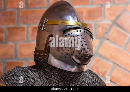 Old historical medieval iron knight helmet armor for ancient warriors protection in combat. Traditional past fighter heavy metal defense equipment for Stock Photo