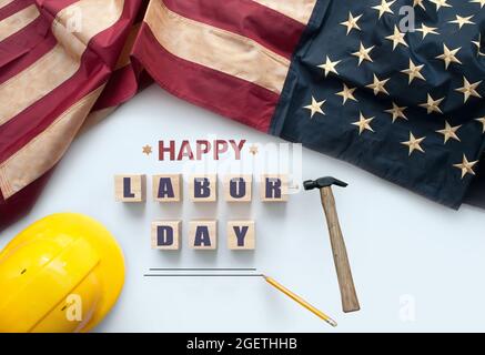 Happy labor day printed on wooden blocks with vintage American flag and work tools Stock Photo