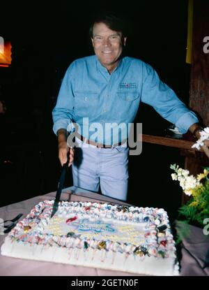 Glen Campbell cuts into his birthday cake at his surprise 60th birthday celebration on April 21, 1996 in Branson, Missouri. Glen Campbell's actual birth date was April 22, 1936 Stock Photo