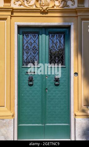 Close-up of the green door of an old holiday villa with iron grate, decorative knobs and a bas-relief on the ledge, Boccadasse, Genoa, Liguria, Italy Stock Photo