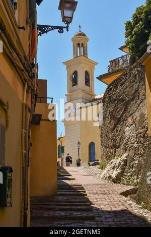 An uphill alley in the old fishing village with the Church of St Anthony on the top in a sunny day, Boccadasse, Genoa, Liguria, Italy Stock Photo