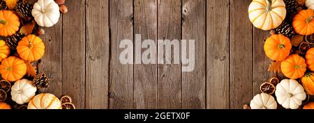 Autumn double border of pumpkins and natural fall decor. Overhead view on a rustic dark wood banner background with copy space. Stock Photo