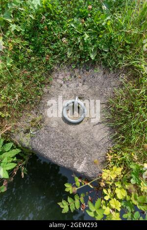 A mooring ring attached to the concrete floor at the side of Cromford Canal in Derbyshire Stock Photo