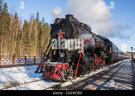 RUSKEALA, RUSSIA - MARCH 10, 2021: Tourist retro train Ruskeala Express with steam locomotive departs from Ruskeala railway station Stock Photo