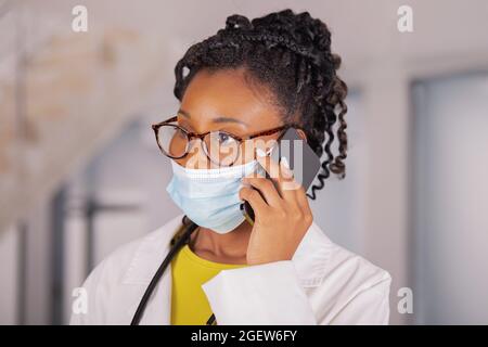 Close up of afro american female doctor using her phone Stock Photo