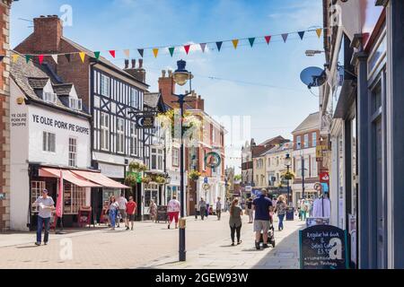 4 July 2019: Melton Mowbray, Leicestershire, UK - People shopping in Nottingham Street on a warm summer day. Ye Olde Pork Pie Shoppe on the left. Stock Photo