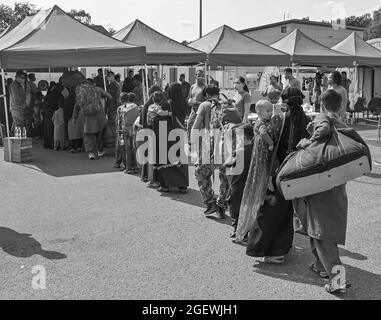 Afghan evacuees line up to be processed at Ramstein Air Base, Germany, Aug. 21, 2021. Ramstein Air Base is providing safe, temporary lodging for evacuees from Afghanistan as part of Operation Allies Refuge. This operation is facilitating the quick, safe evacuation of U.S. citizens, Special Immigrant Visa applicants and other at-risk Afghans from Afghanistan. Evacuees will receive support, such as temporary lodging, food, medical care as well as religious care at Ramstein Air Base while preparing for onward movements to their final destinations. (U.S. Air Force photo by Senior Airman Caleb S. K Stock Photo