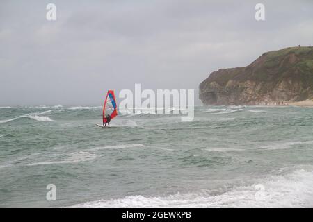 Windsurfer on the rough, stormy sea of the Skagerrak, Jutland, Denmark, in the distance the Bulbjerg, a limestone cliff Stock Photo