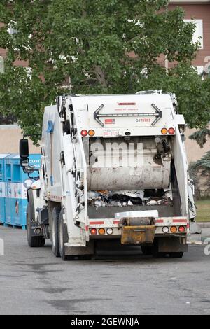 August 21 2021 - Calgary , Alberta Canada - Garbage truck collecting rubbish from bins Stock Photo