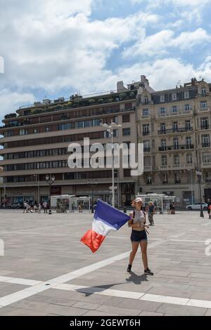 August 21, 2020, Toulon, var, France: A demonstrator brandishes a French flag on the Place de la Liberté during the protest.Saturday 21 August 2021 is the sixth day of mobilization against the vaccine policy and the application of the health pass. In Toulon (Var), according to the authorities there were 6000 demonstrators. The main slogans criticize the government decisions as dictatorial. Some of the placards included signs and slogans comparing the current situation with the Nazi regime and the Second World War. (Credit Image: © Laurent Coust/SOPA Images via ZUMA Press Wire) Stock Photo