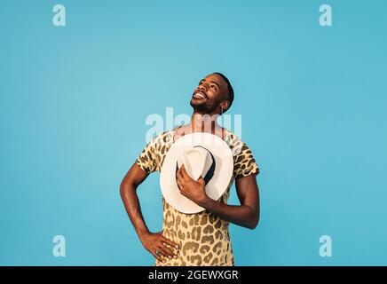 Young handsome man holding straw hat on chest and looking up Stock Photo