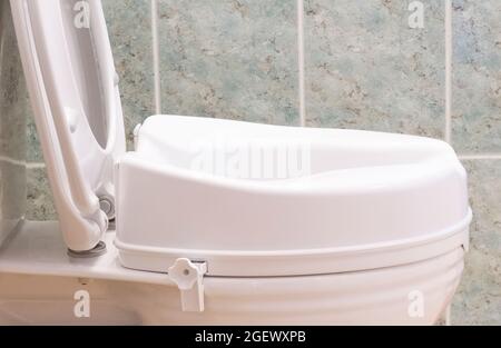 Toilet with height extension for disabled senior person indoors in house Stock Photo