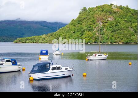 Single white boat alone on lake during summer Stock Photo