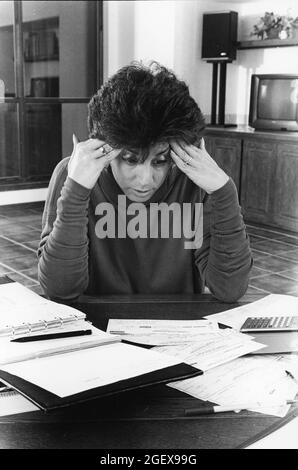 Austin Texas USA, circa 1992: Woman working on household budgets at home after balancing personal checking account. MR-EH0357   ©Bob Daemmrich Stock Photo
