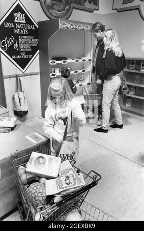 Austin Texas USA, circa 1994: Young girl mimics adult behavior while playing in the child-sized mock grocery store at the Austin Children's Museum. ©Bob Daemmrich Stock Photo