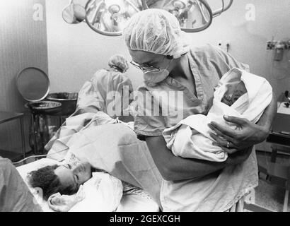 Austin Texas USA, 1982: Childbirth story that ran in the Austin American-Statesman in 1982. Attending nurse presents swaddled newborn to mother. File 82-48 Box #12  birth was 6-2-1982. ©Bob Daemmrich Stock Photo