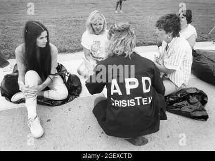 Austin Texas USA, circa 1984: Member of Austin Police Department crisis team talks to 'victims' during mock disaster drill. ©Bob Daemmrich Stock Photo