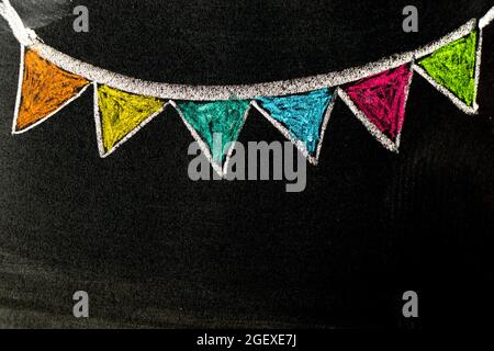 Colorful chalk handdrawing in hanging party flag shape on blackboard or chalkboard background with copy space Stock Photo