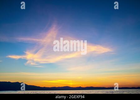 Unusal but beautiful sunset over Lake Tahoe with whispy triange shape in sky and swirls near horizon Stock Photo