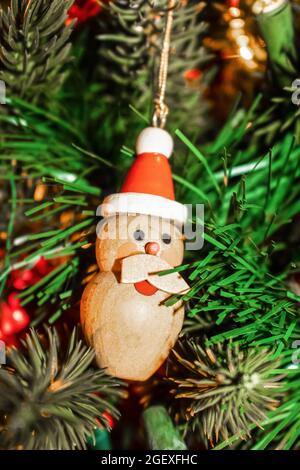 Vintage Retro wooden snowman Christmas ornament with broken mustache hanging on tree Stock Photo