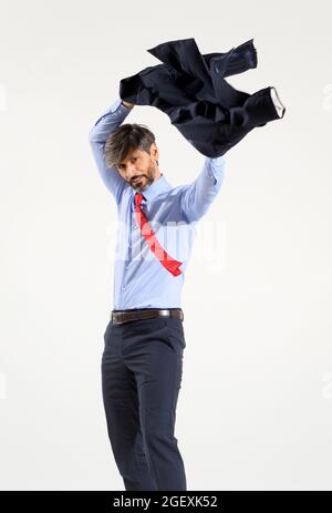 Stylish businessman putting on his suit jacket isolated on white swinging it above his head as he inserts his arms in the sleeves Stock Photo