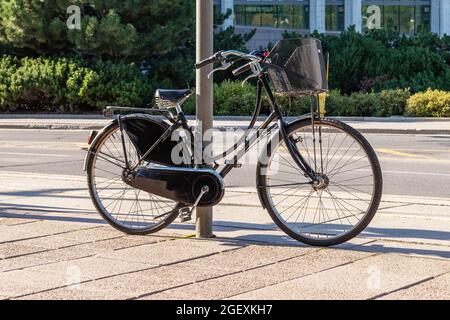 Ottawa, Canada - August 2, 2021: The bike parked next to pole, secured with locking device on the street in downtown of Ottawa, Canada. Healthy lifest Stock Photo