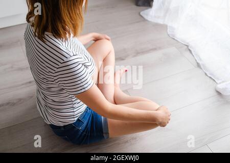 Young woman meditates or practicing yoga in the living room Stock Photo