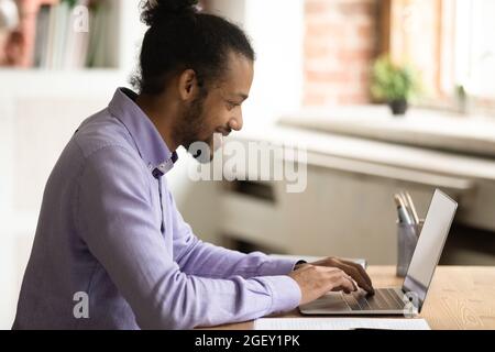 African man text messages, working on online project use laptop Stock Photo