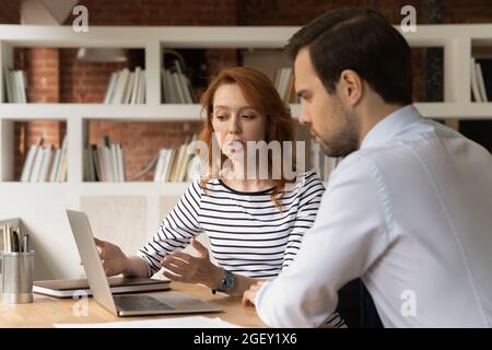 Sales manager showing to client online presentation on laptop Stock Photo