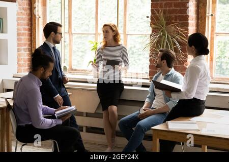 Diverse company staff members listen leader at briefing in office Stock Photo