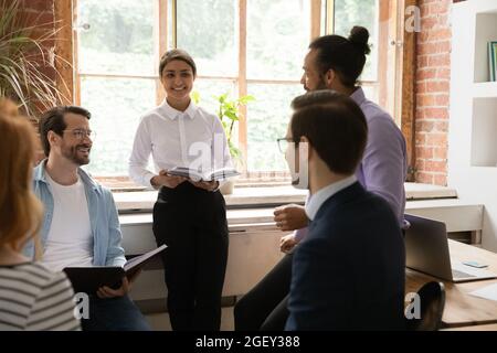 Multi ethnic teammates discussing common project at briefing in office Stock Photo