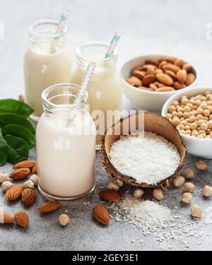 Alternative types of vegan milks in glass bottles on a  concrete background. Top view Stock Photo