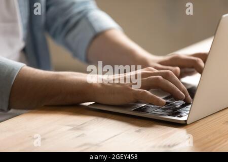 Closeup view male hands typing message on laptop keyboard Stock Photo