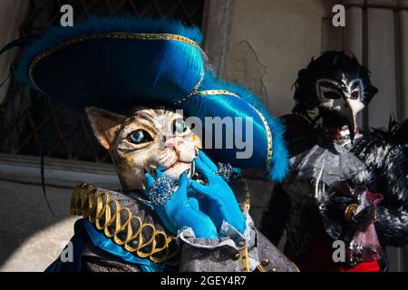 A male and female wearing cat and bird masks and carnival costumes in Venice, Italy Stock Photo