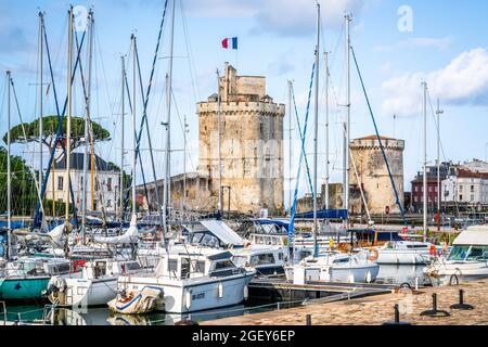 28 July 2021 , La Rochelle France : The Chain and Saint Nicolas towers of La Rochelle in middle of sailing boats of the old port of La Rochelle France Stock Photo