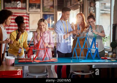 two group of employees making paper towers, separated in different competitive teams. Teambuilding. Stock Photo