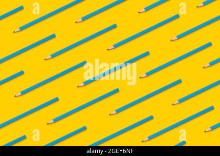 Pattern composition of blue pencils on a yellow background. Top view. Flat lay. Back to school concept. Stock Photo