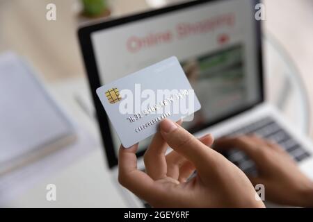 Closeup female hands holdinh card paying via e-bank on laptop Stock Photo