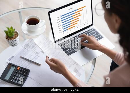 Woman prepare report makes expenses statistics, above closeup view Stock Photo